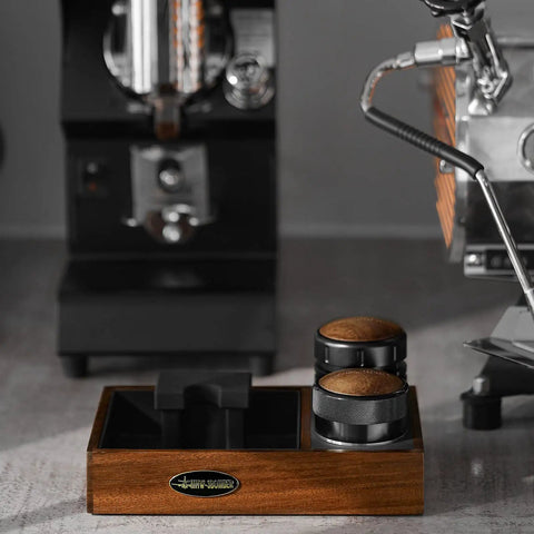 58mm Espresso Coffee Distributor Leveler with Stepless Height Adjustment on wooden base near espresso machine.