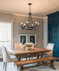 Black Farmhouse Wagon Wheel Chandelier With Six Lights, 24 Inch Rustic Pendant Ceiling Light in dining room setting.