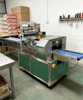 Smooth Operator Compact Horizontal Flow Pack Machine Small Shrink Wrapper Rock Solid Performance 50 To 80 Wraps Per Minute in use at a food stall.