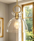 Super Sleek Brushed Gold Pendant Light For Kitchen Island Featuring Fully Adjustable Hanging Cord And Large Clear Glass Shade.