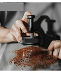 Level Up Your Home Barista Setup With This Dope 58Mm Espresso WDT Tool Featuring Six Heat Resistant Needles Adjustable Depth Control And Hidden Magnetic Storage For Zero Fuss Morning Routines, black WDT tool in use over coffee grounds.