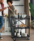 Portable Folding Service Cart With Three Tiers, 330 Lbs Capacity, Rolling Utility Cart On Wheels in home setting