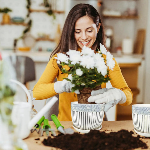 Woman planting flowers in Dope Three Piece Ceramic Plant Pots Set With Drainage Holes And Saucers For Indoor And Outdoor Vibes