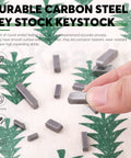 Close-up of a gray carbon steel round-ended shaft key held between fingers; part of 140-piece Keadic set (8–30mm).