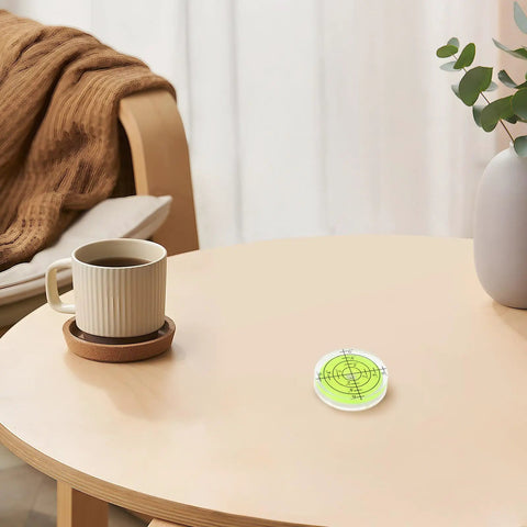 Green mini bubble level on a wooden table, part of 4 Piece Mini Bubble Level Tool Set for Construction and Mechanical Work