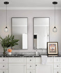 Bathroom with Three Light Matte Black Pendant Lighting With Transparent Glass Shades above mirror and sink