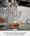 Barista Grade Espresso Machine With Integrated Conical Burr Grinder Bean To Cup Coffee Maker Featuring Manual Steam Wand For Creamy Microfoam And Show Stopping Latte Art In Modern Black Truffle Finish Top Shelf extracting espresso into a clear glass.