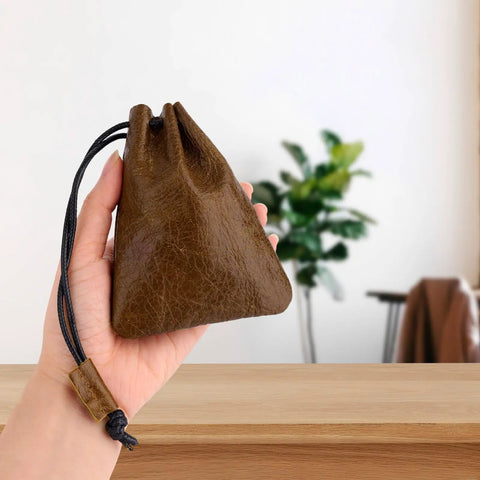Hardy Cowhide Leather Drawstring Pouch With Vintage Retro Finish Designed For Hauling Your Daily Grind Essentials Travel Toiletries And Quick Pocket Stash, held in hand with soft inner walls visible.