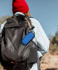 Blue Hard Travel Case For KardiaMobile EKG Monitors 1 Lead 6L 6L Max With Pill Box attached to a backpack in an outdoor setting.