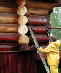 Person applying Heavy Duty 2 In 1 Log Home Stain And Sealer Formulated With High Solids for wood protection on logs.