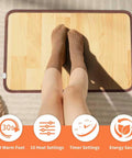 Person with socked feet on Cozy Feet Warmer Floor Mat With Ten Heat Settings And Timer, Fast Heating Under Desk Foot Pad