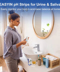 Woman in bathroom using Must Have At Home pH Test Strips 4.5 To 9.0, 200 Count Litmus Paper for Urine and Saliva