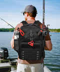 Heavy Duty Fishing Tackle Backpack With Dual Rod Holders on angler's back, 26L durable 600D Oxford, water resistant, black.