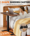 Woman using Tiltable Mobile Standing Desk With Wheels Pneumatic Height Adjustable Overbed Table For Laptop And Meals next to bed
