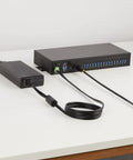 Built Like A Tank 16 Port Industrial USB 3.2 Gen 1 Hub With Heavy Duty Metal Casing and power supply cables on a table.