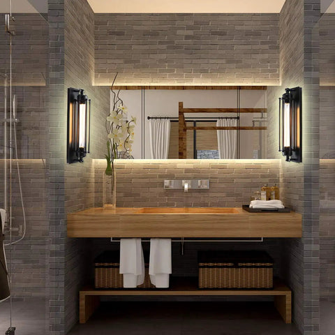 Modern bathroom with wooden vanity, brick wall tiles, and wall-mounted lights beside a mirror, accented with plants and towels.