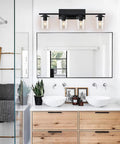Dope Four Light Matte Black Vanity Lights With Clear Glass Shades in modern bathroom setting above double sink