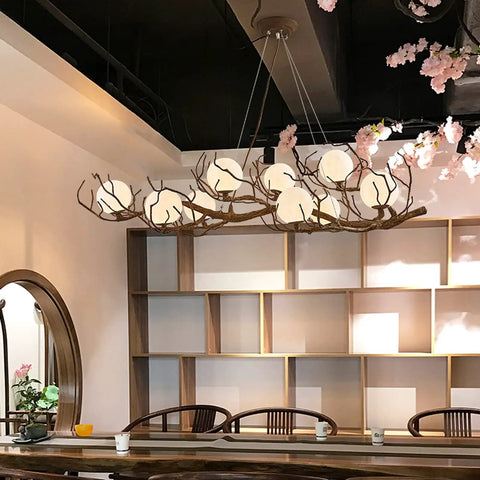 Sleek Vintage Moon Led Chandelier Boasts Natural Branch Silhouette And Nine Soft Glowing Fixtures To Level Up Your Chill Living Space While Durable Rust Resistant Build Guarantees Lasting Appeal For Bedrooms Or Cozy Restaurants in a modern interior.