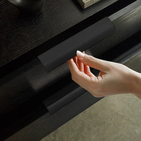 Hand holding one of 24 Pack Sleek Black Aluminum Back Mount Finger Edge Drawer Pulls 4.7 Inch Hidden Cabinet Handles on drawer