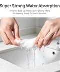 Hands holding a wet towel demonstrating the super strong water absorption feature of 14 Pack Compressed Travel Towel Tablets Ultra Absorbent Water Activated Compact Cloth Dudes Swear By These Fast Expand Wipes For Camping Hiking And Road Trips.