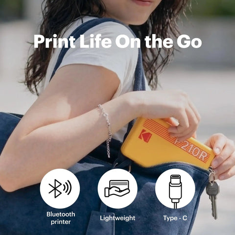 Woman placing Mini 2 Retro 2x3 Portable Photo Printer into a bag, Bluetooth-enabled, print instantly in color, compact and lightweight.