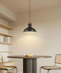 Three Pack Industrial Pendant Lights Black Metal Finish hanging above a round dining table with chairs in a modern rustic style room