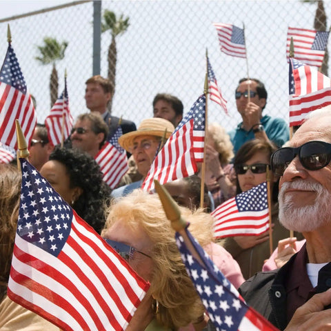 Crowd waving All American Flags On Sticks 12 Pack 8x12 Inch Wood Stick Flags With Kid Safe Spear Top at outdoor event