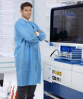 Man wearing Dental Disposable Lab Coat Set Knee Length 3 Pockets Soft Knit Cuffs And Collar SMS 45G Material Blue in dental lab