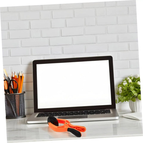 Laptop on desk with Phone Screen Opening Tool With Suction Cup Pliers For Easy DIY Repairs placed in front, showing tool's size and design.