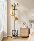Black freestanding coat rack stand with umbrella holder, 16 hooks, located in cozy room near window with coats, hats, bags.