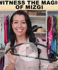 Woman holding Heavy Duty Black Plastic Hangers Pack Of 50 With Rounded Shoulders that Prevent Bumps, in closet background.