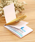 Open booklet of PH Test Strips 0-14, 80 Count Litmus Paper for Saliva Urine Water Soil Testing, on wooden table with dried flowers