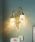 Modern Double Head LED Wall Sconce Rock Solid Hardware Body and Prismatic Crystal Details Knockout Vibe Enhancement in Bedroom or Corridor Luxury Illumination, gold finish, clear crystal shade, mounted on wall.