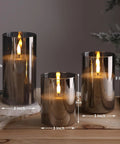 Smoke Grey Glass Flameless Pillar Candles With Remote Control And Flickering LED Battery Candles Set Of 3 on wooden table