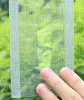 Hand applying Heavy Duty Window Screen Repair Tape For Mosquito Screens Tents And Patio Nets Easy Peel And Stick Patch Kit to a screen