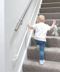 Fully Adjustable Toddler Stair Handrail Built Like A Tank For Little Ones Grows With Your Kid To Deliver Kid Approved Safety And Rock Solid Support Down Each Step Zero Hassle Standard Mount Kit, toddler using handrail on carpeted stairs.