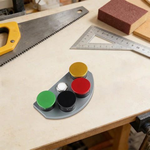 Four Compartment Watch Oil Cup With Color Coded Wells For Quick Lubricant Application on a workbench with tools.
