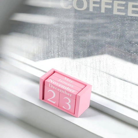 Pink Decor Wooden Desk Calendar Blocks Perpetual Block beside rainy window, compact cute desk accessory, stylish pink room decor.
