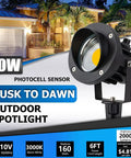 Outdoor Led Spotlight With Dusk To Dawn Sensor 20W 2000 Lumen Super Bright 3000K Warm White Waterproof Landscape Lights For Your Yard Garden Tree Flag Decor 6 Ft Cord Two Pack shown in front of illuminated house facade