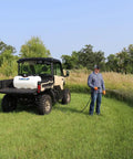 40 Gallon Deluxe UTV Spot Sprayer With 2.2 GPM 70 PSI Max mounted on UTV, person spraying grass, adjustable spray gun reaches 25 feet