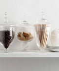 Set Of 3 Clear Glass Apothecary Jars With Lids For Candy Buffets And Home Decor Tall 10 Inch And Two 9 Inch Jars With 4.5 Inch Openings on shelf