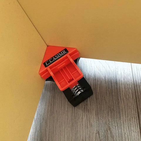 Right Angle Corner Clamp Set 4 Pack Adjustable Single Hand Spring Loaded Clip holding wooden boards at 90 degrees