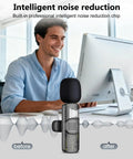 Man using 4 in 1 Wireless Lavalier Microphone With Universal Receiver For iPhone Android Cameras Computers USB C 3.5mm And USB Plug Dual Mic Setup For TikTok Videos And Vlogs Black with noise reduction feature at a desk.