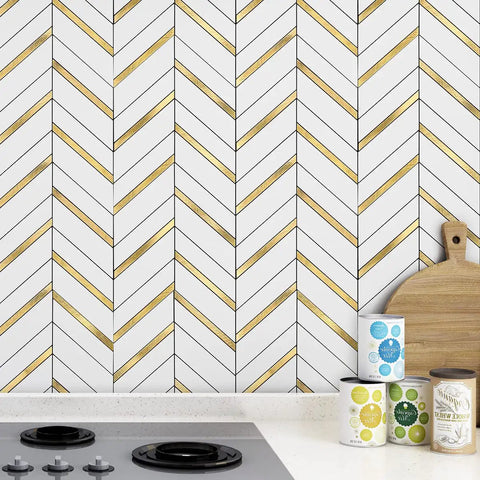 Herringbone Peel And Stick Backsplash Tiles With Self Adhesive Marble Look For Kitchen And Bath 10 Sheets Covering About 10 Sq Ft Waterproof Heat Resistant Stain Resistant Anti Scratch White Mixed Gold Metal installed behind a stove in a kitchen.