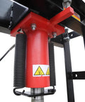 Close-up of the hydraulic cylinder of the Real Deal 40 Ton Air Hydraulic Shop Press with warning labels and metal components.