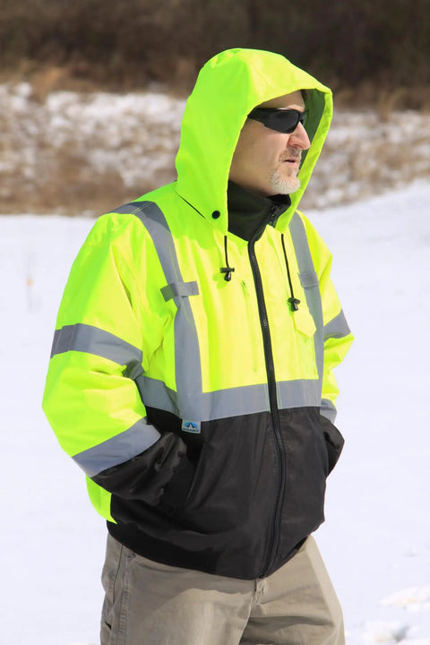 Man wearing Waterproof Class 3 Hi Vis Lime Fleece Bomber Safety Jacket With Detachable Hood, 2 Inch Reflective Tape in snowy field
