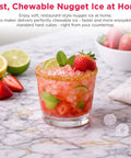 Glass of cocktail with strawberries and mint on countertop, showcasing ice from Touchscreen Nugget Ice Maker For Countertop With 33 Lbs Daily Capacity, Easy Tap Control, Sonic Style Crunchy Ice For Cocktails And Sodas, Sleek Slate Finish, Home Bar Essential.