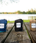 Three ecox outdoors parachute nylon hammock bags on a picnic table, including Parachute Nylon Hammock Single With 2 Tree Straps.