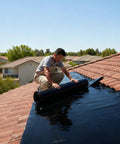 Man installing Rock Solid Self Adhesive Rubber Roofing Membrane Roll 39 By 164 Feet Waterproof Leak Tape on a tiled roof.