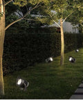AC85‑265V IP65 Rotatable LED Flood Light (Green 25w) illuminating a garden path beside trees at dusk.